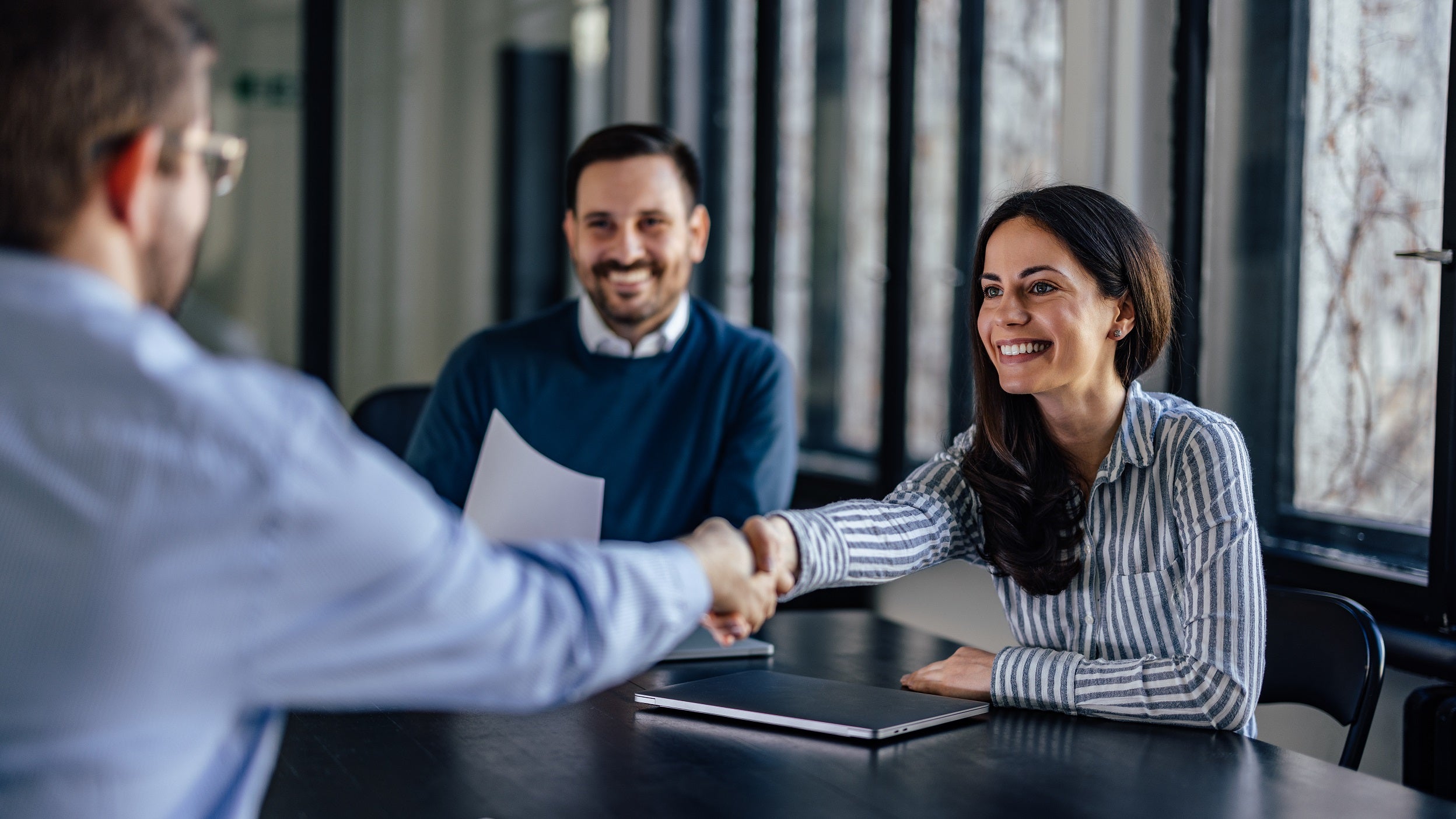 Man and woman shaking hands with advisor