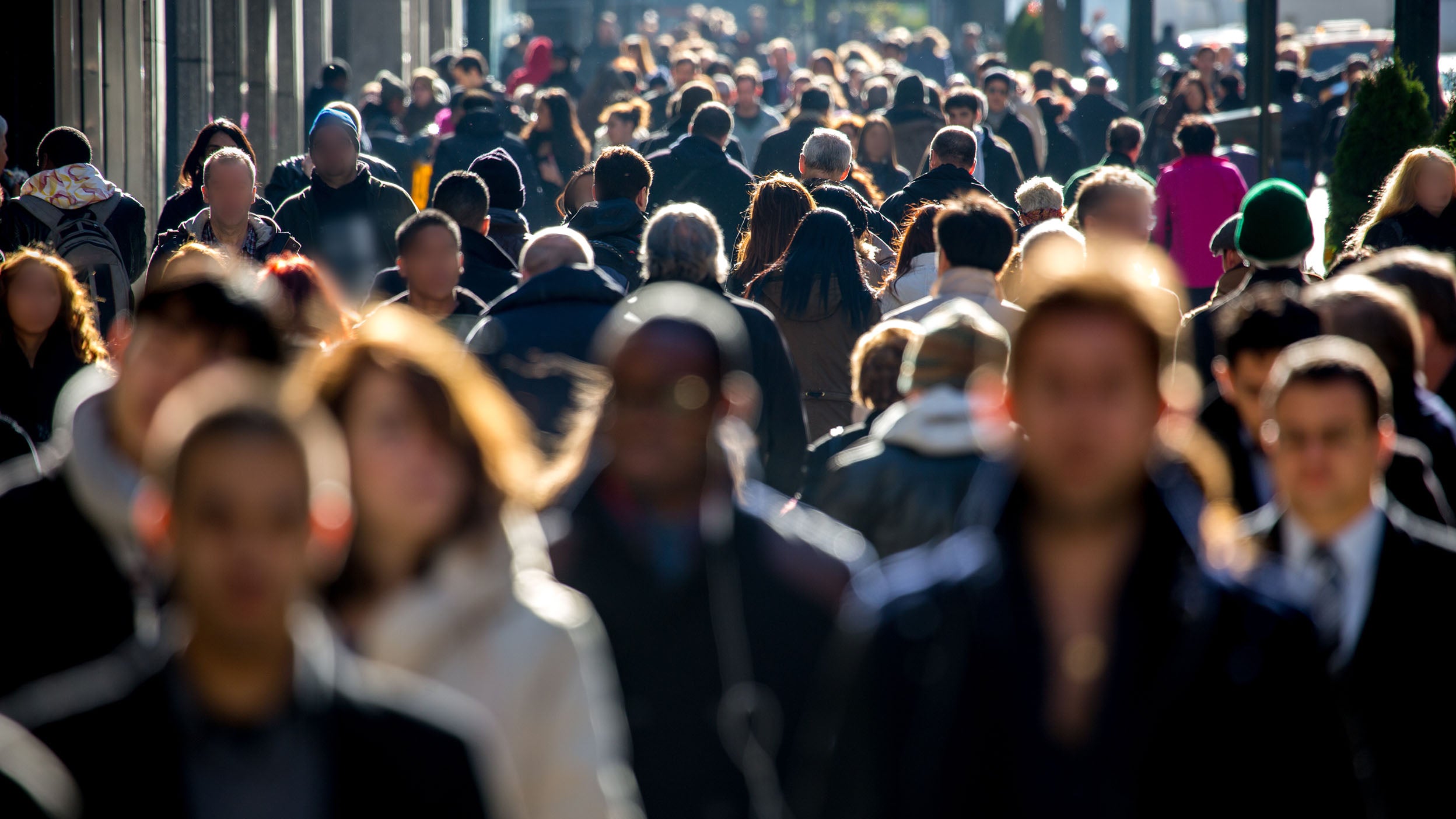 Anonymous crowd of people walking on city street