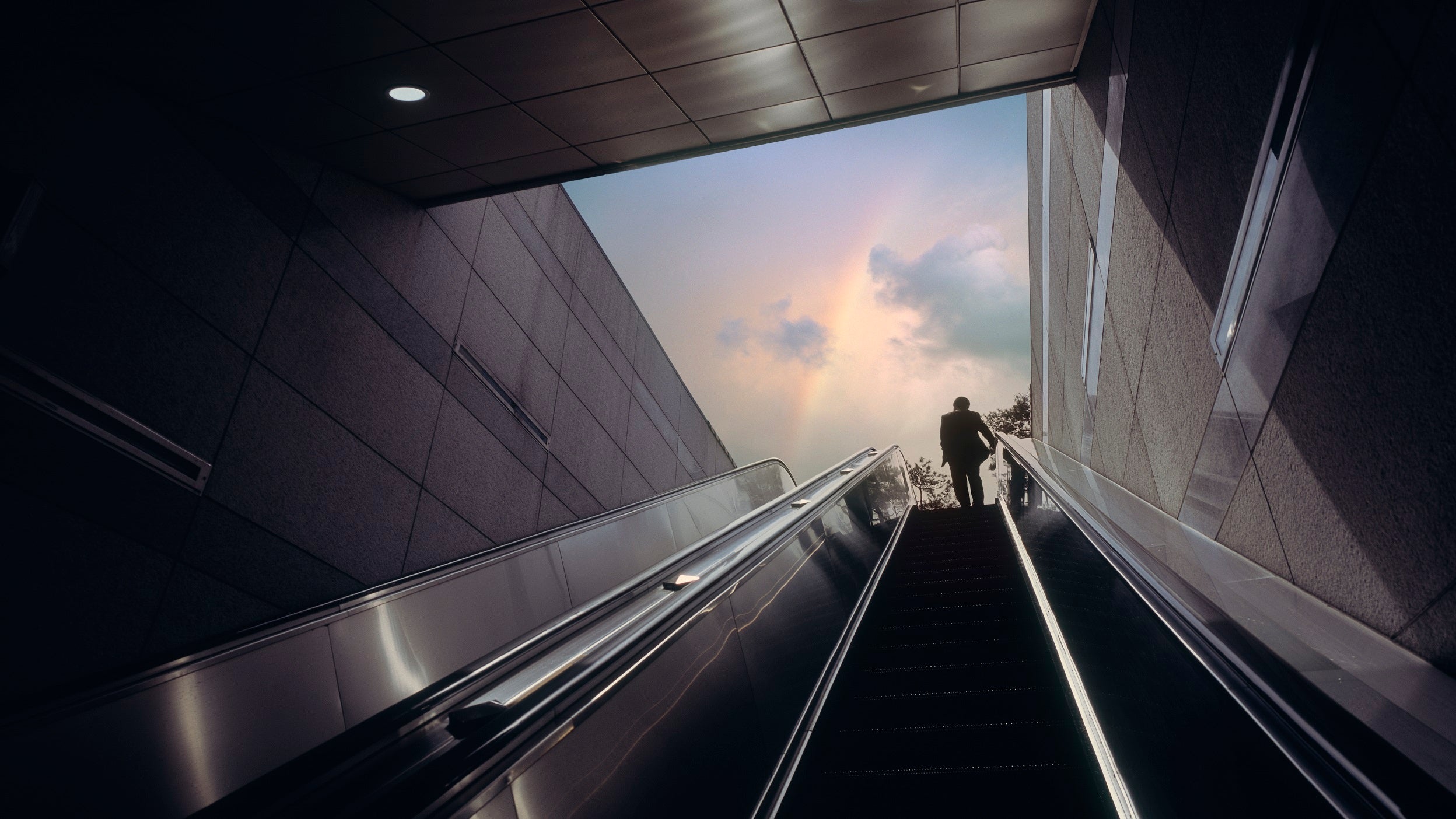 Woman ascending escalator 