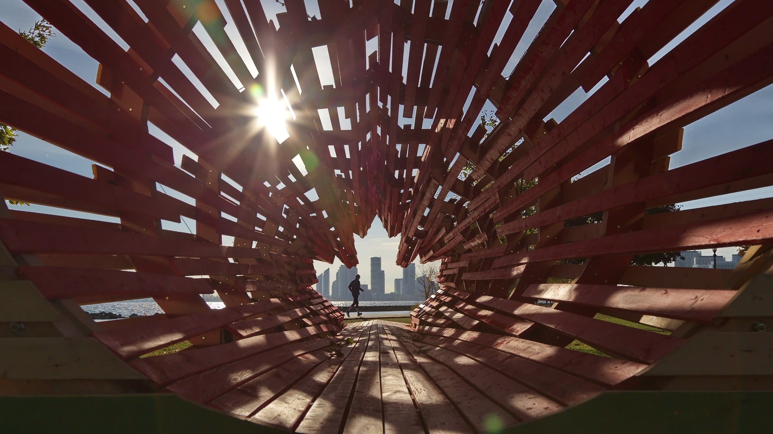 Person walking through a maple leaf shaped tunnel opening