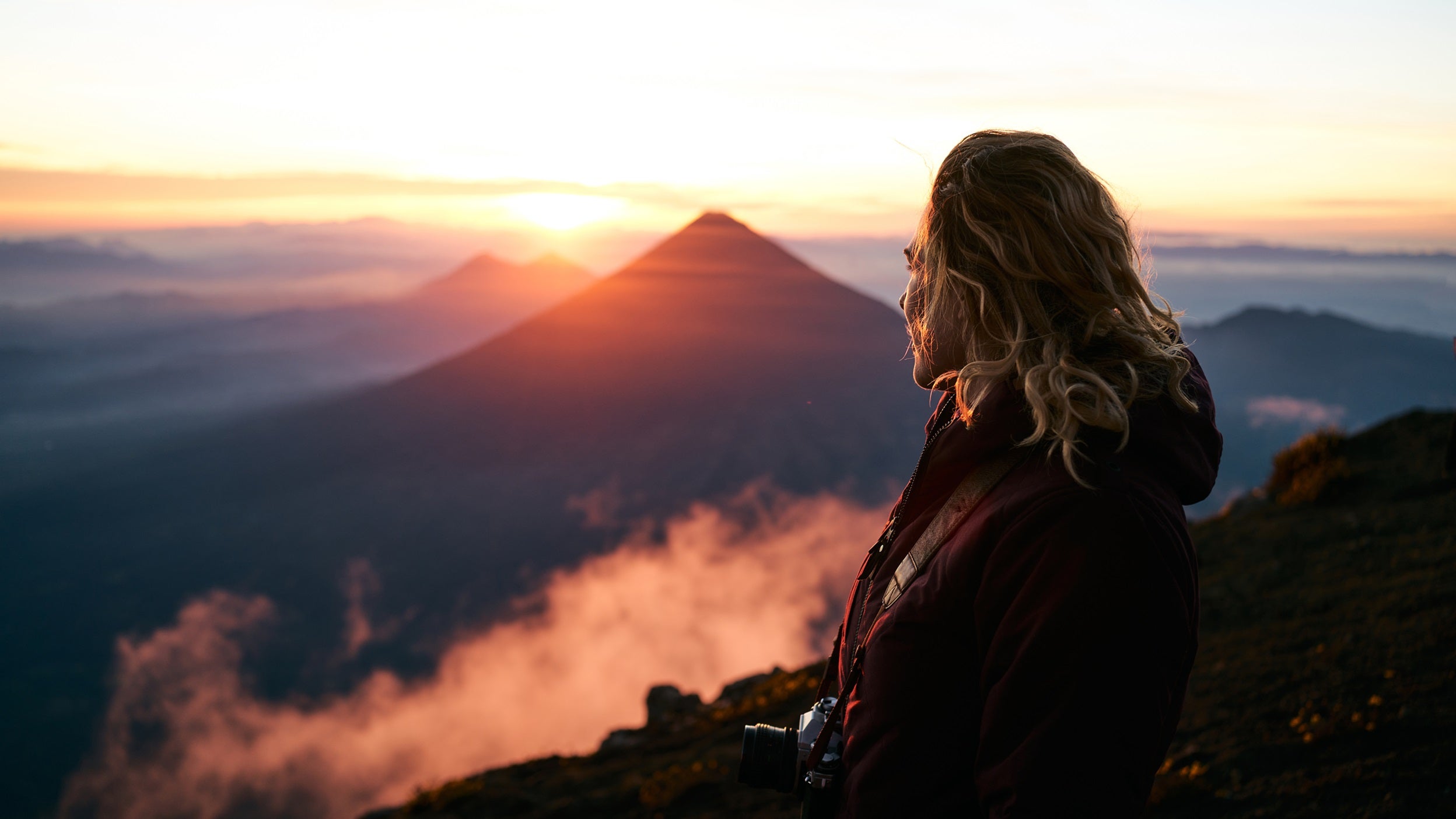 Woman on top of mountain at sunrise