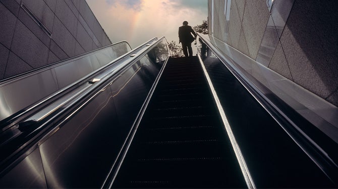 man ascending escalator