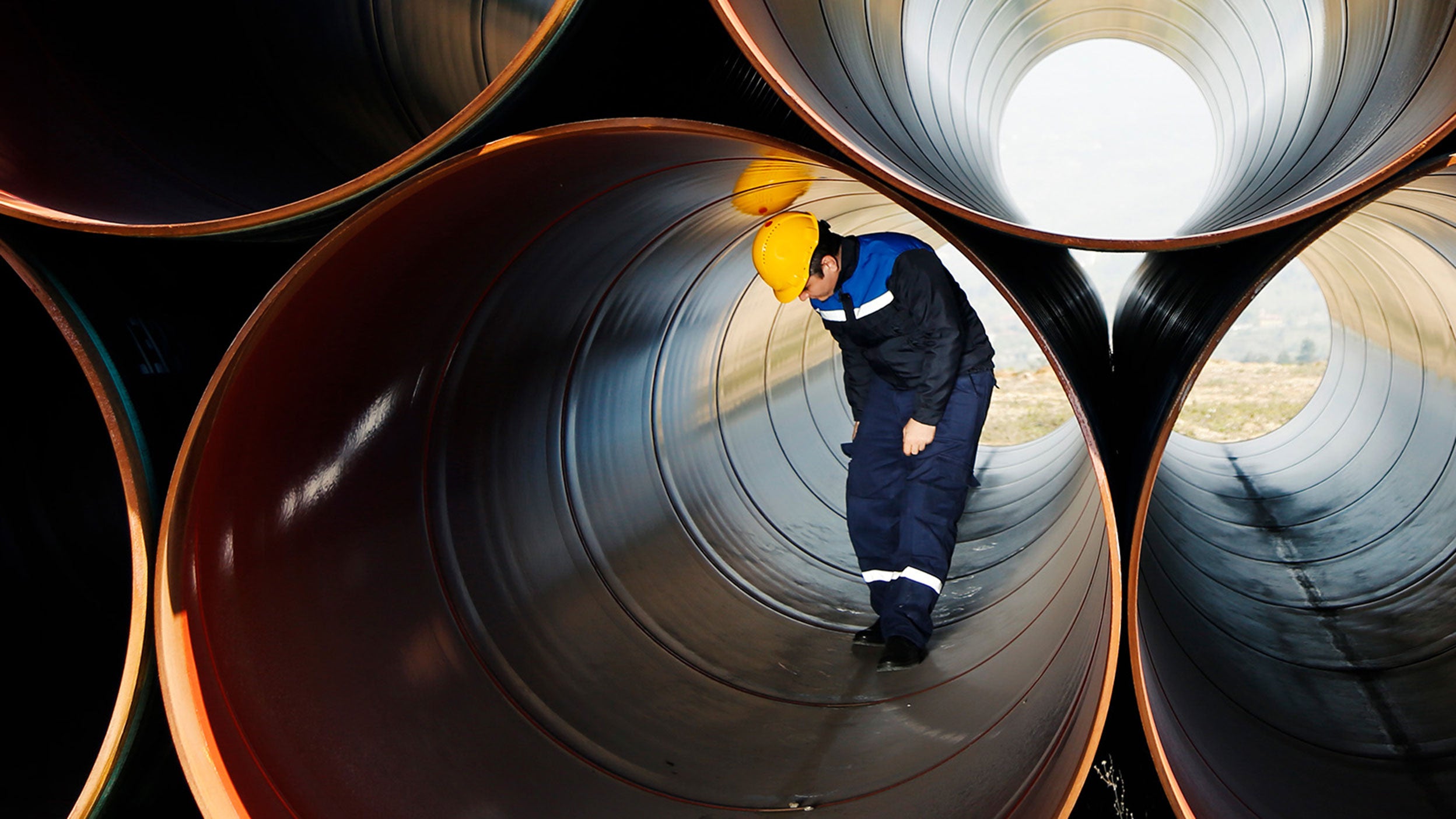 Ingenieur die de binnenkant van een metalen buis inspecteert