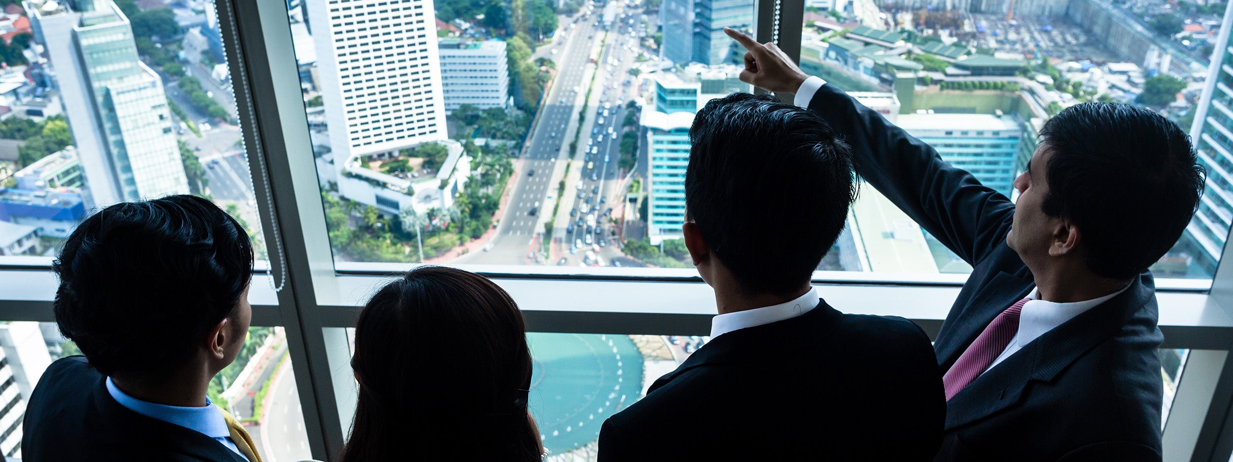 Groupe d’hommes d’affaires asiatiques regardant les immeubles de la ville