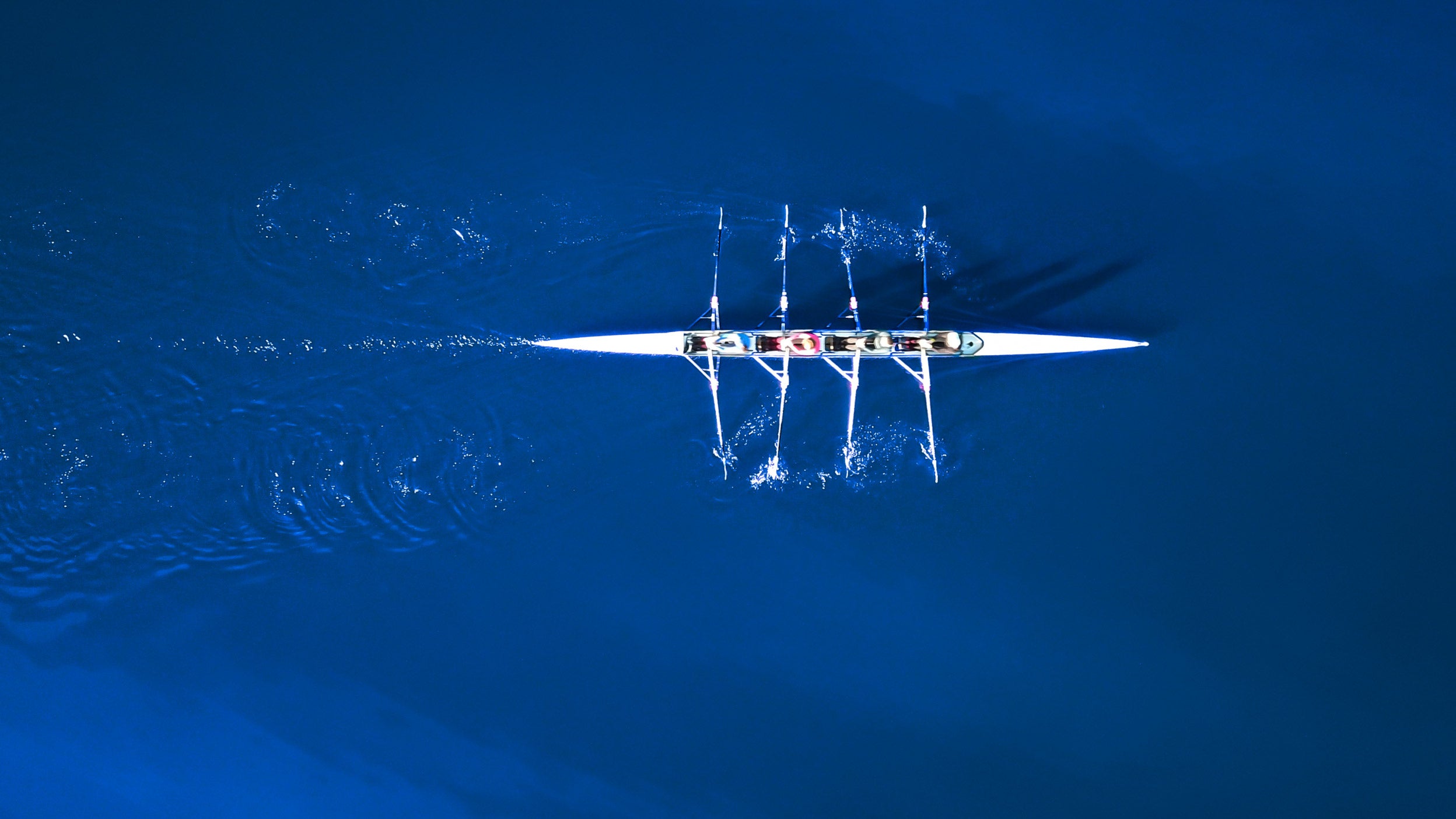 Aerial view of a rowing boat surrounded by classic blue water