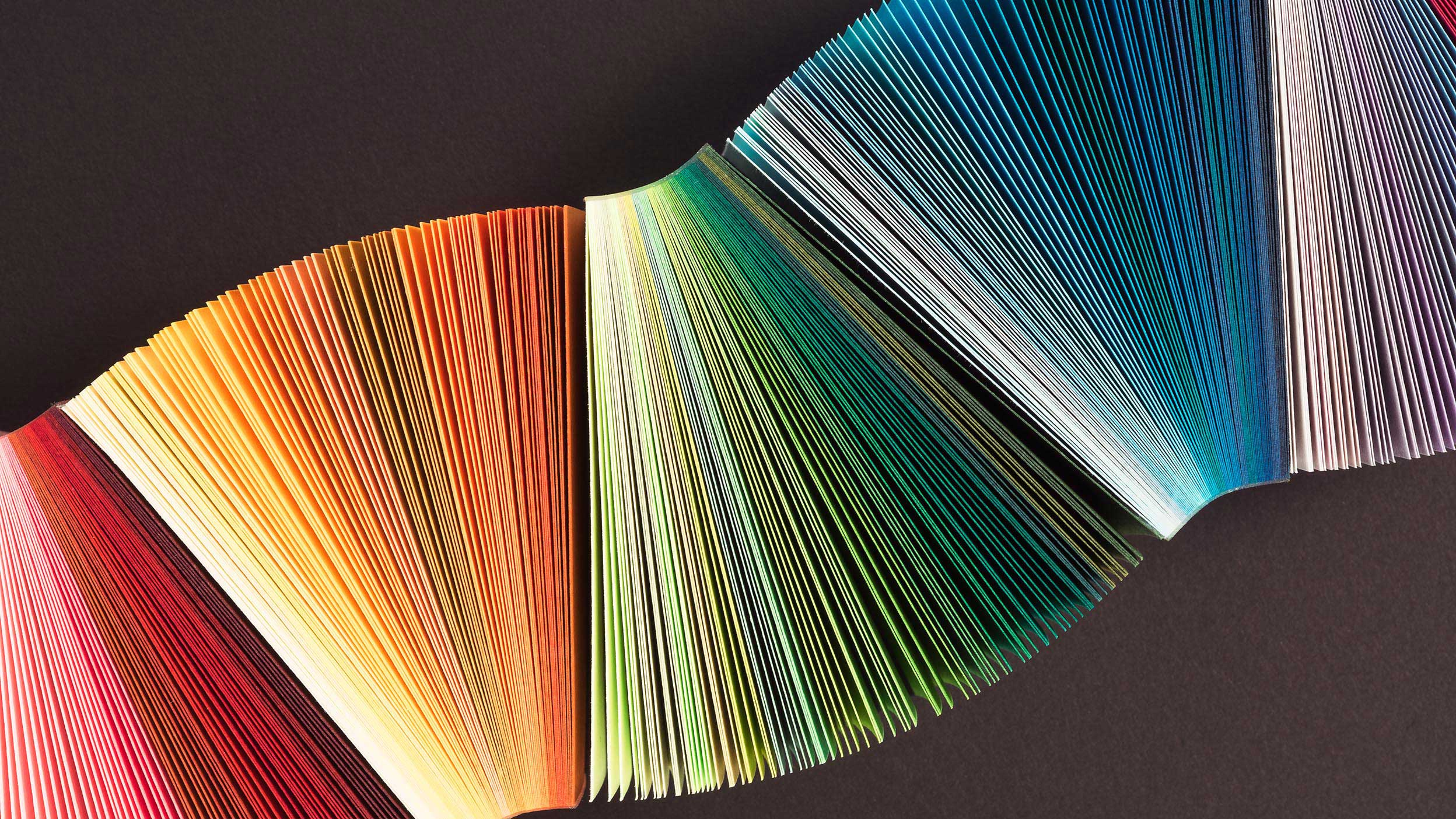 Opened colourful books from above before a brown background