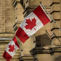 Canadian%20flags%20hang%20on%20display%20outside%20the%20Office%20of%20the%20Prime%20Minister%20and%20Privy%20Council%20building%20in%20Ottawa,%20Ontario,%20Canada.%20Photographer:%20Brent%20Lewin/Bloomberg