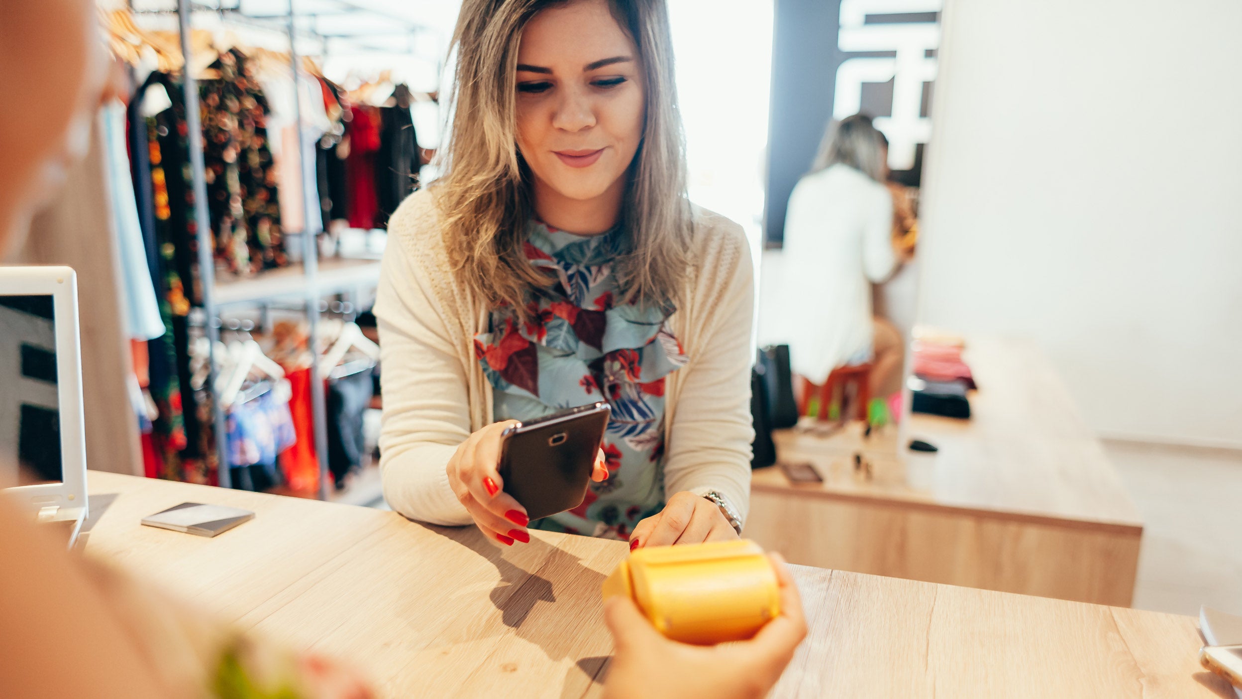 Woman paying with NFC technology on mobile phone, restaurant, cafe, bar, clothing store