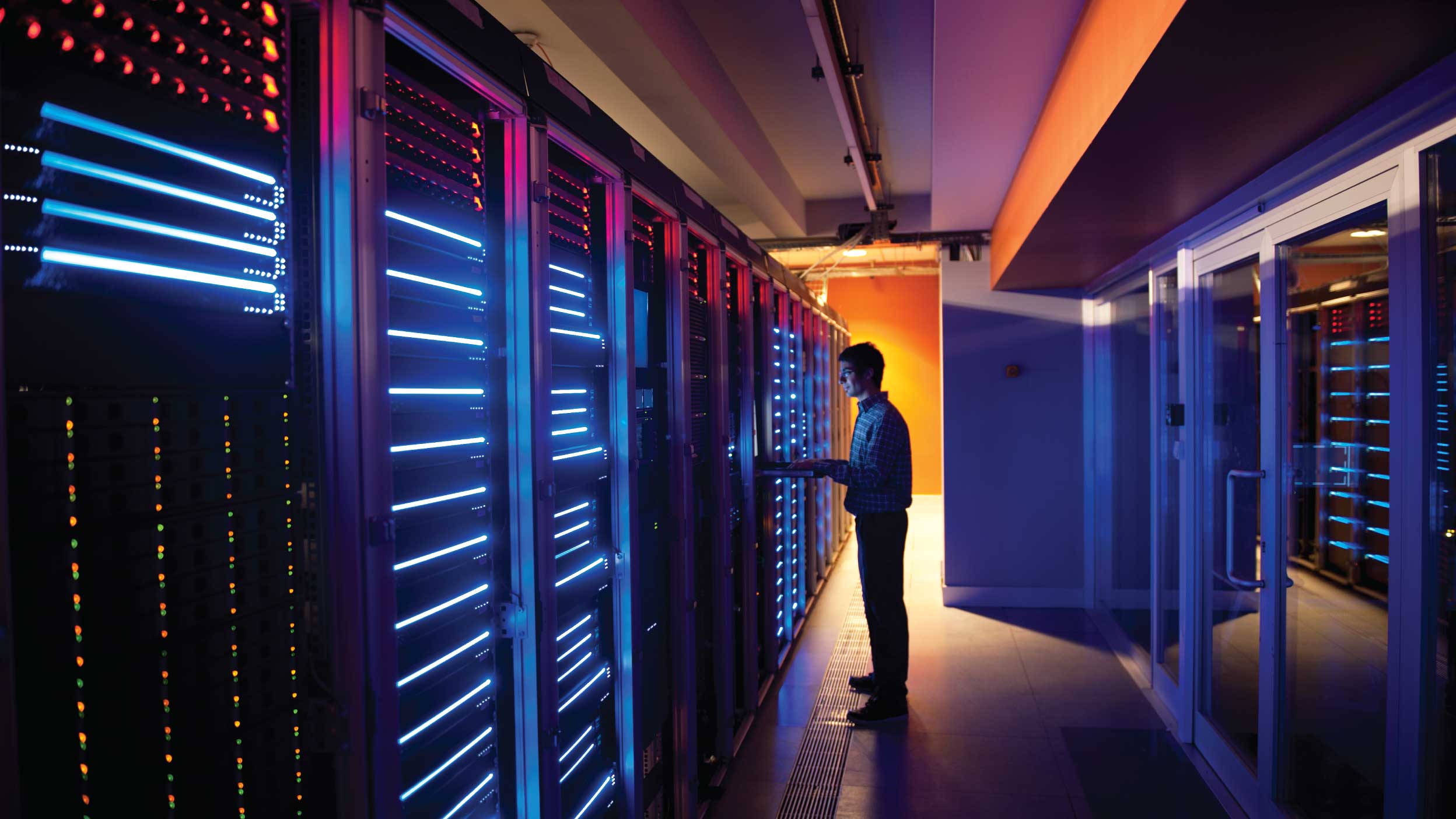 Modern interior of server room in datacenter. IT Engineer in Action Configuring Servers