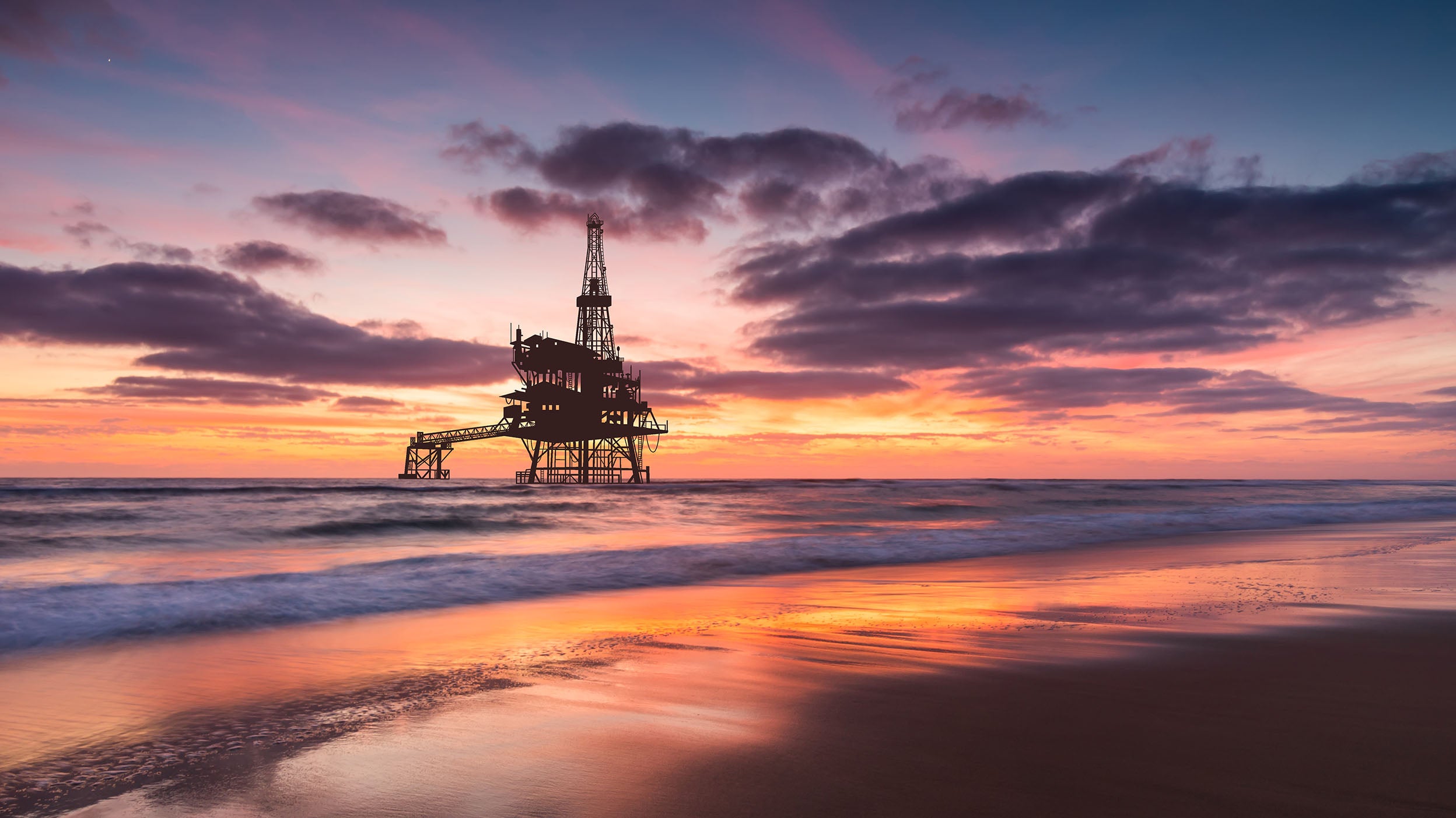 An offshore oil rig at sunset