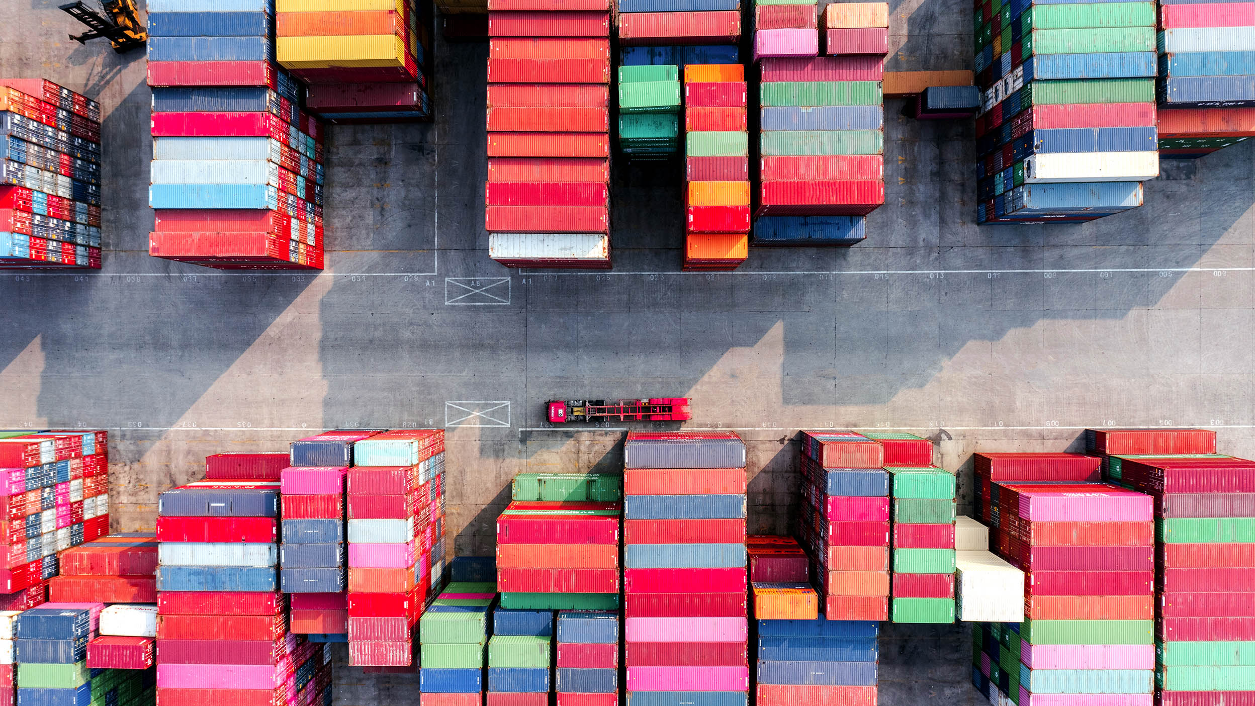 Aerial view of shipping containers from above, in an array of colors.