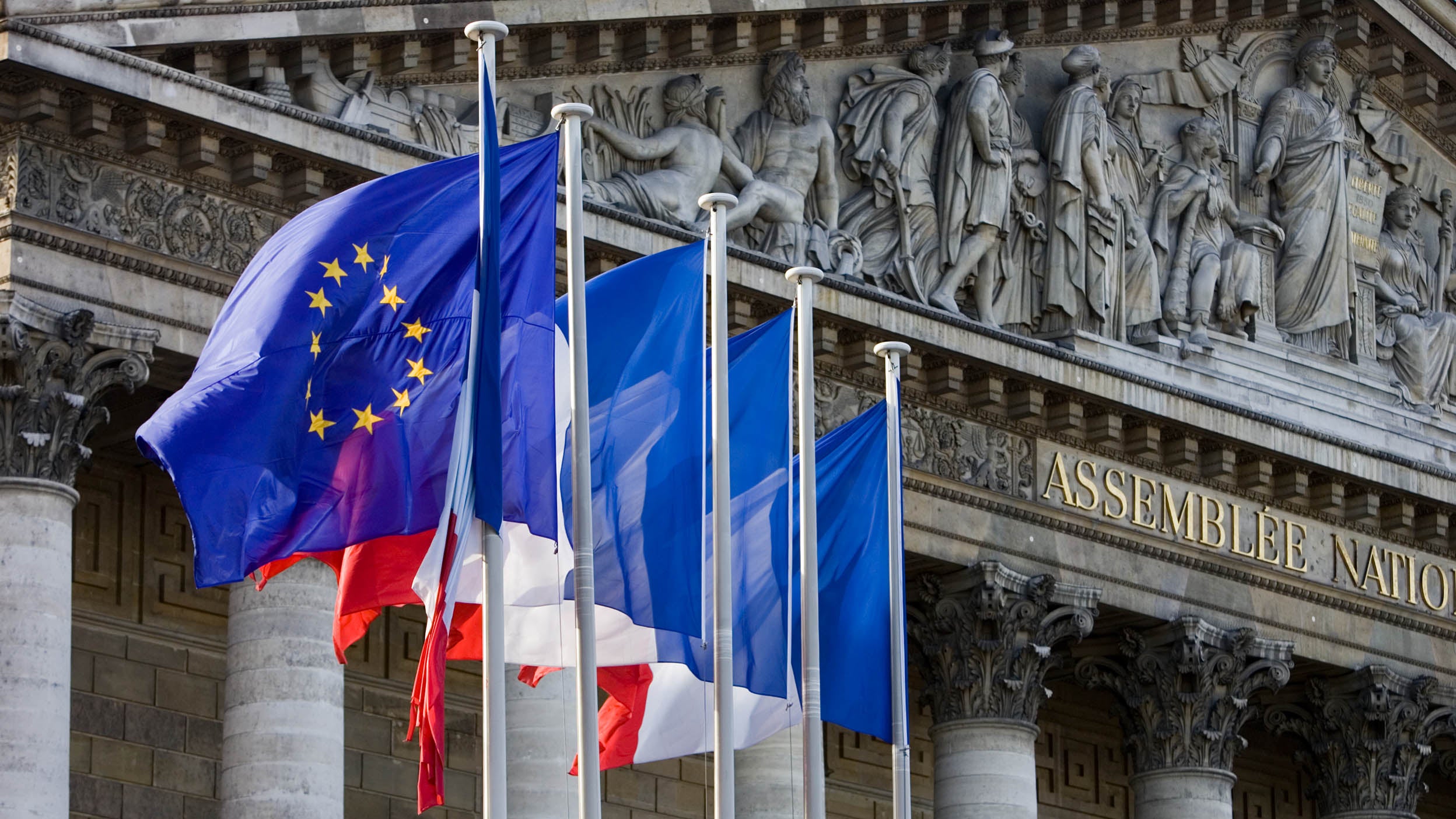 Flags fly on flagpoles outside Assemble Nationale, Palais Bourbon, Central Paris, France
