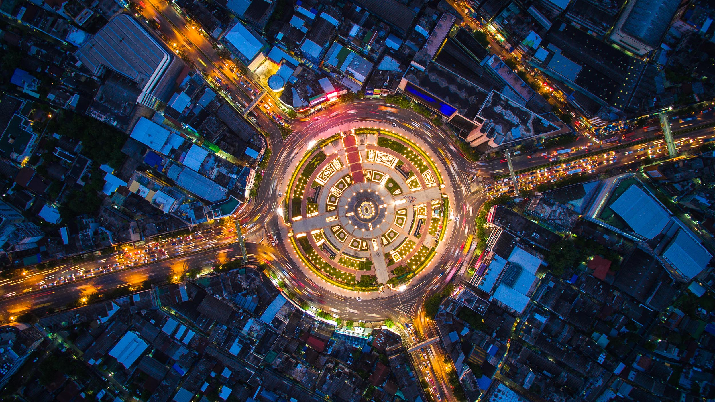Large roundabout traffic circle photographed from above at night.