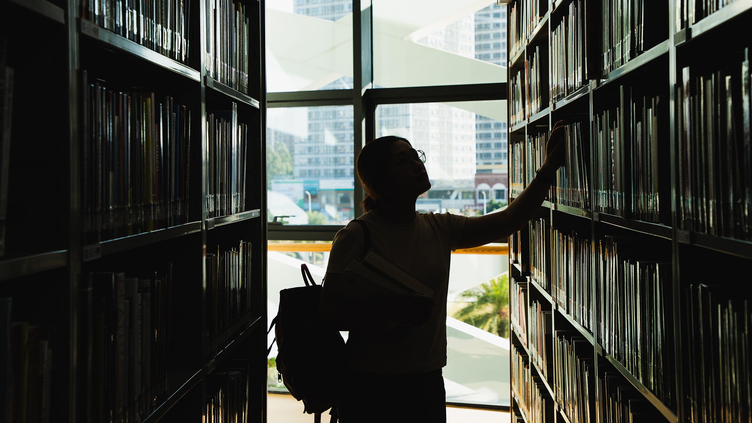 Woman looking at books in library