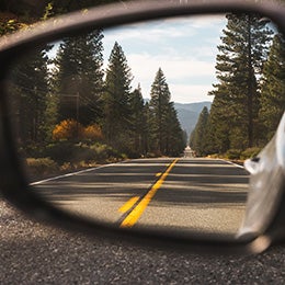 Rearview%20car%20mirror%20with%20trees%20in%20the%20background