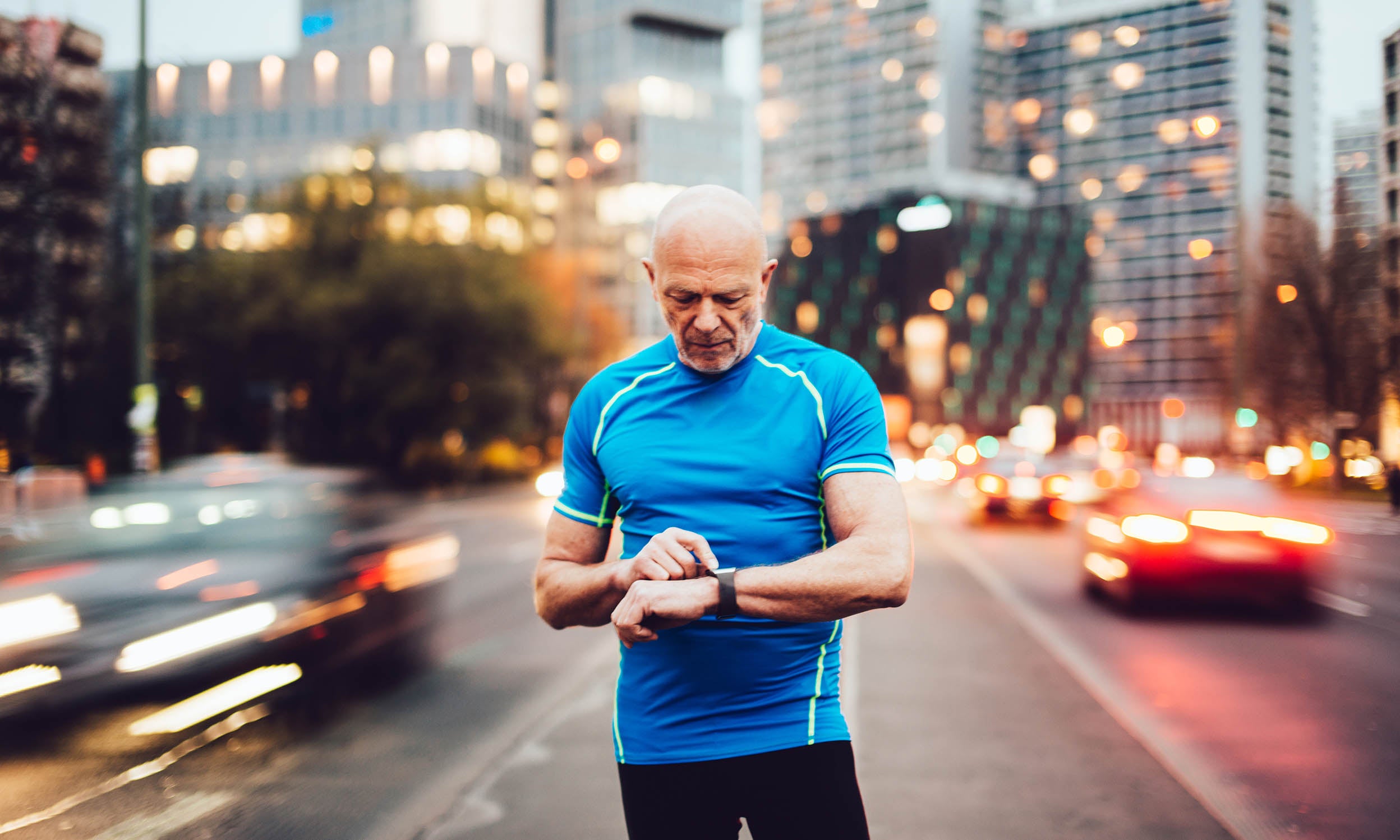 A man checks his smart watch, one of the many pieces of wearable technology that you get exposure to, as an investment theme, through Invesco QQQ ETF