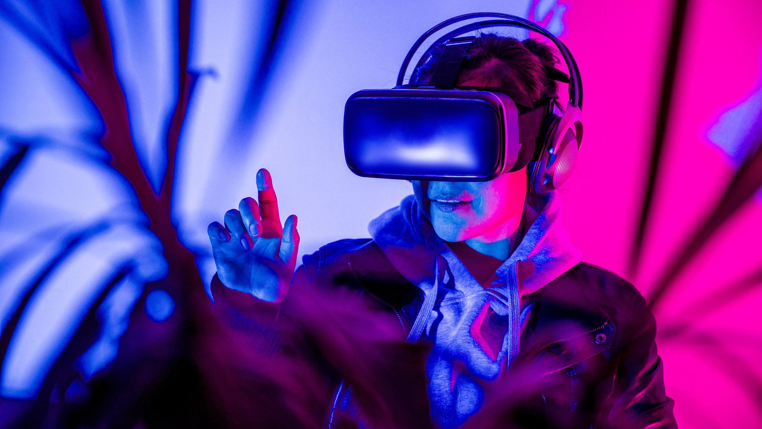 Una mujer con gafas de RV interactúa con la realidad virtual y disfruta del metaverso.