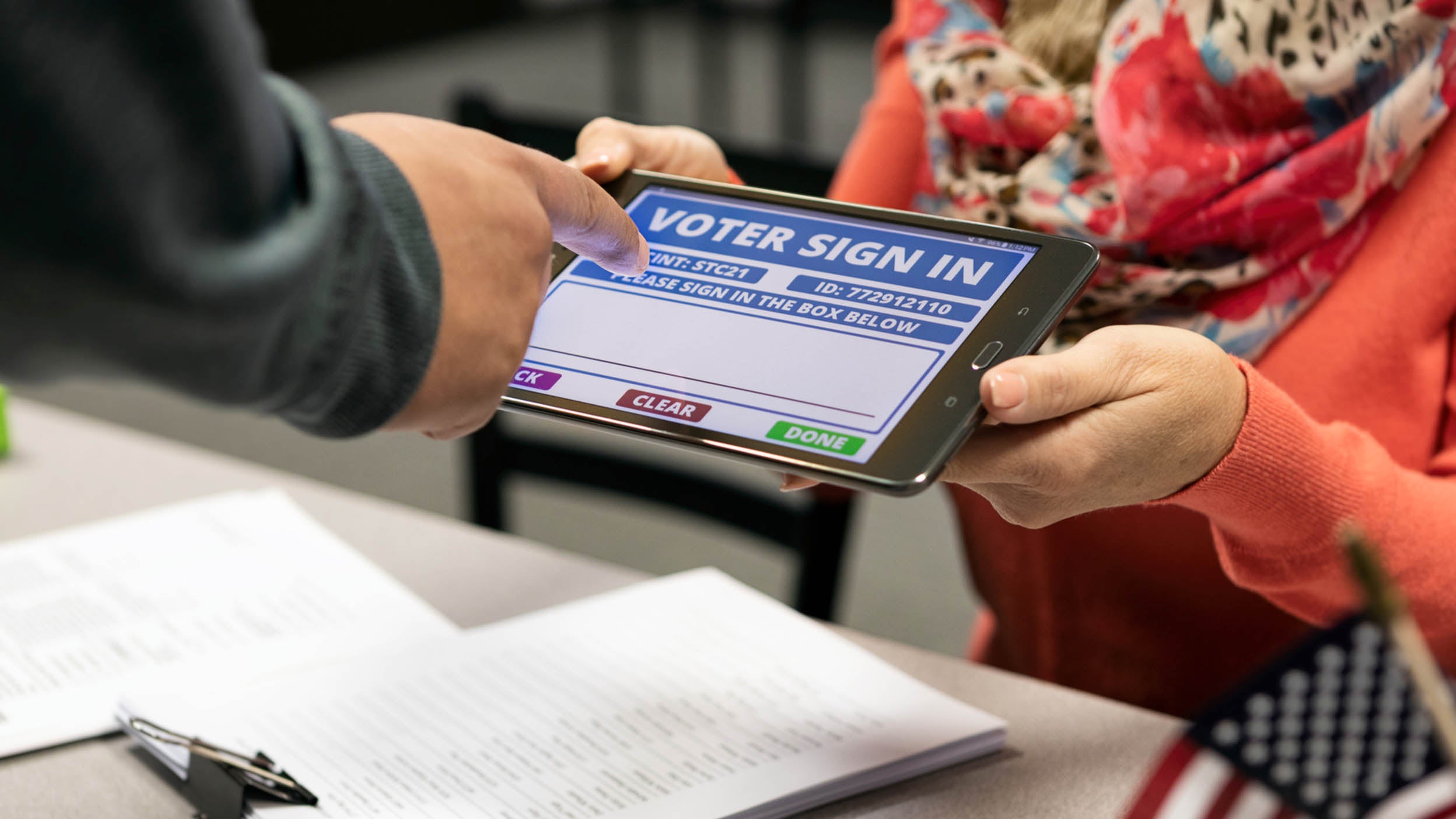 Man signs name on tablet computer for voting