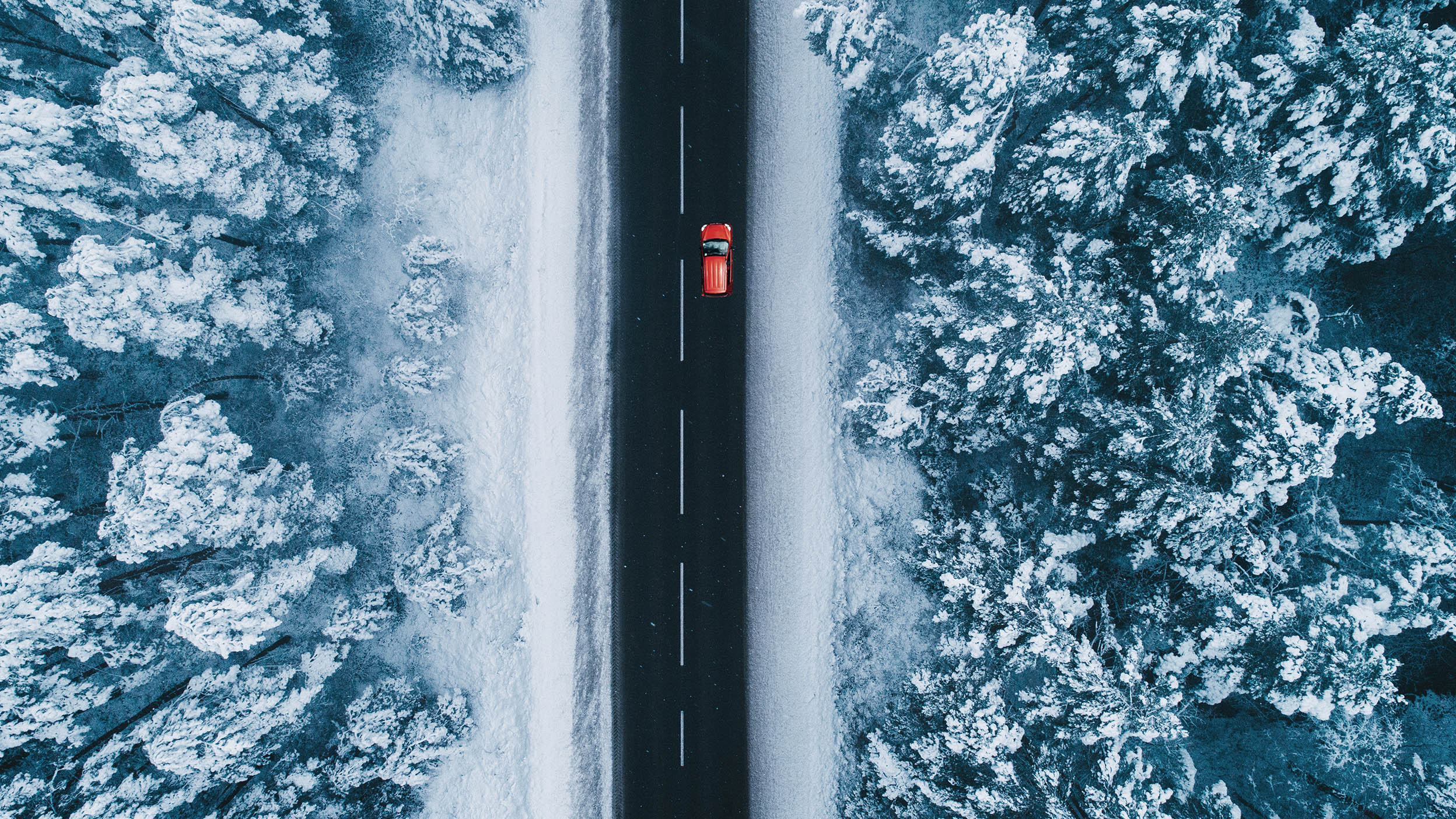 Aerial of city streets, covered in snow at dusk.