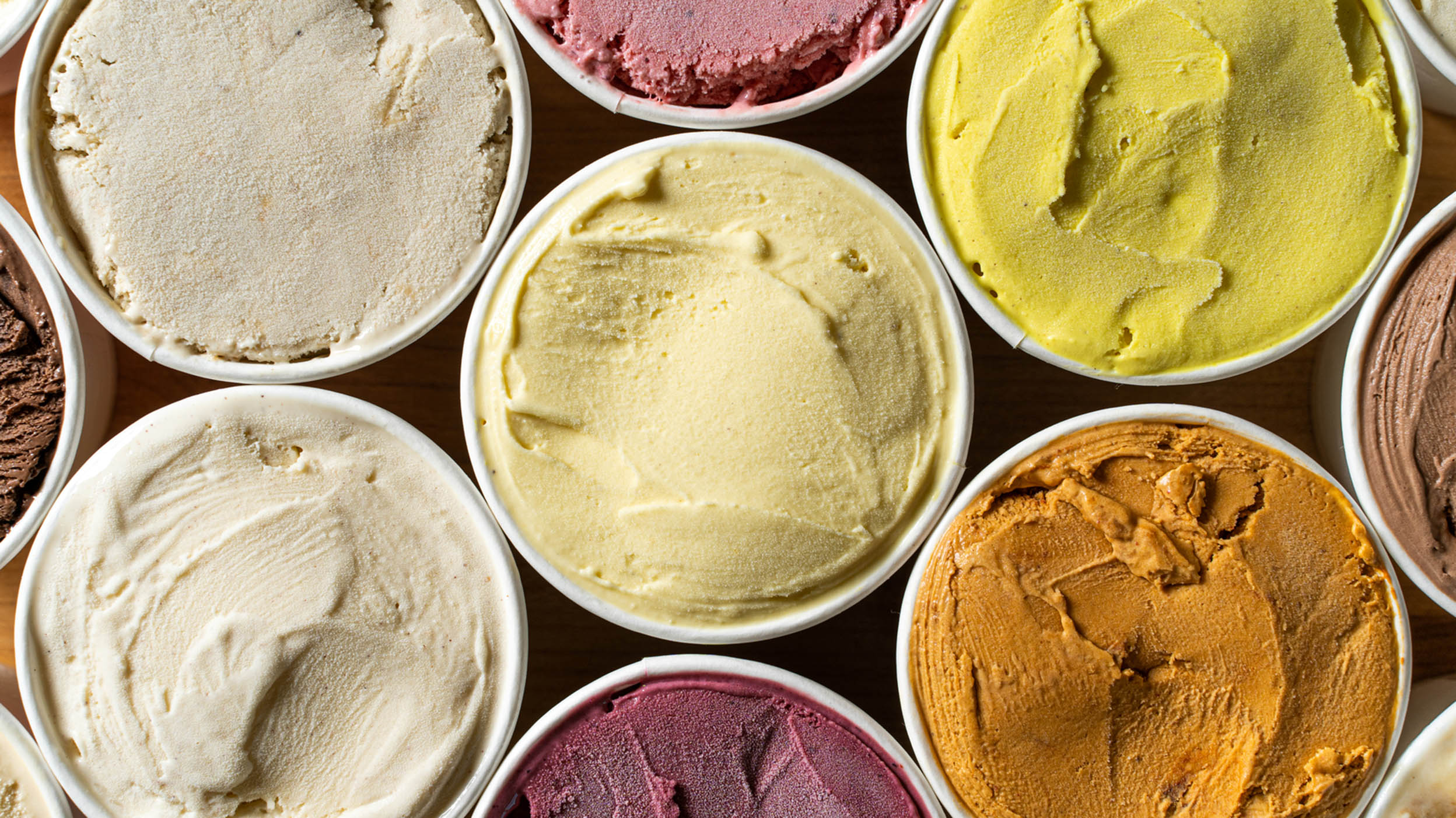 Various buckets of multiple ice cream flavors.