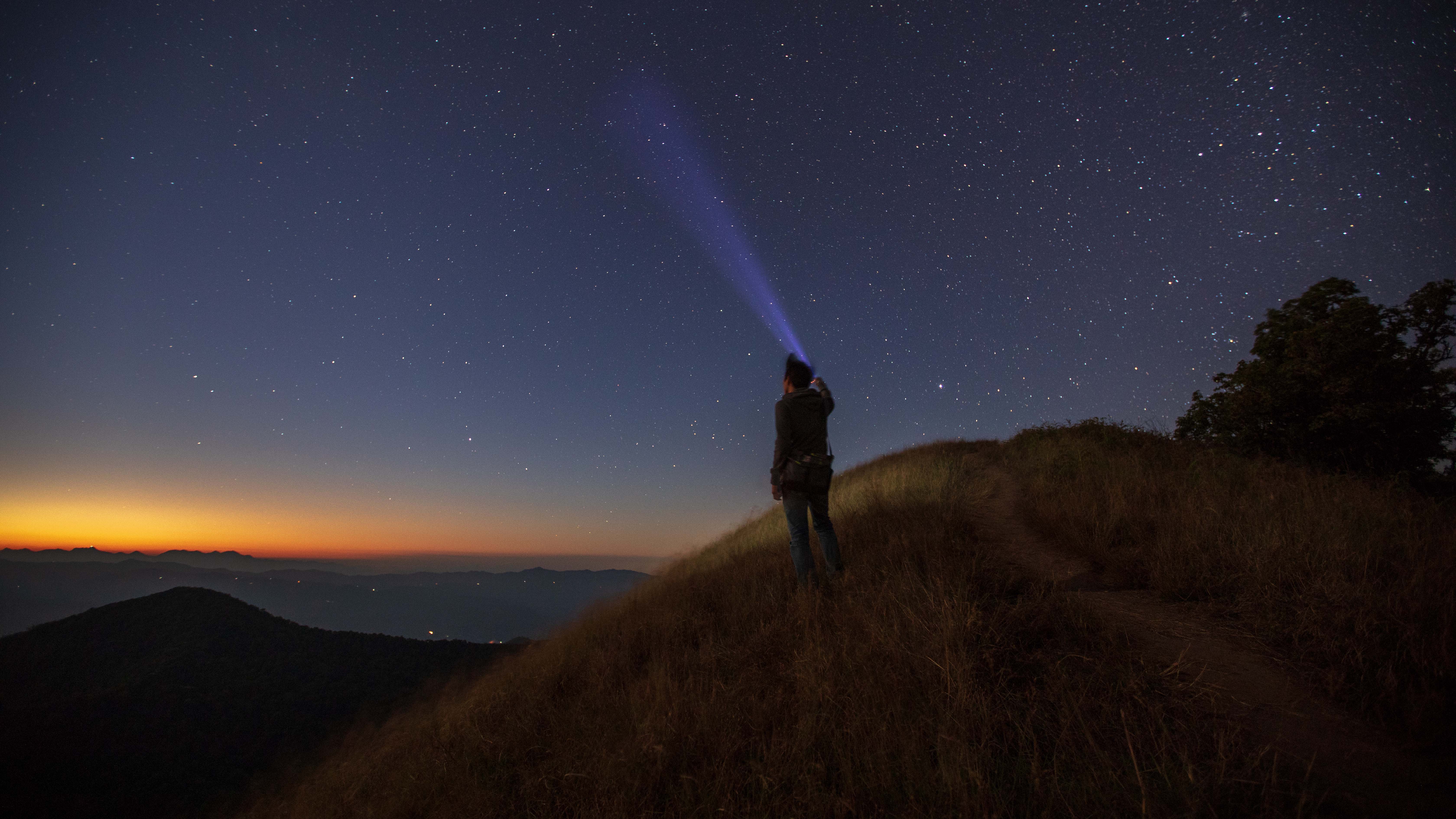 Man pointing torch at the sky