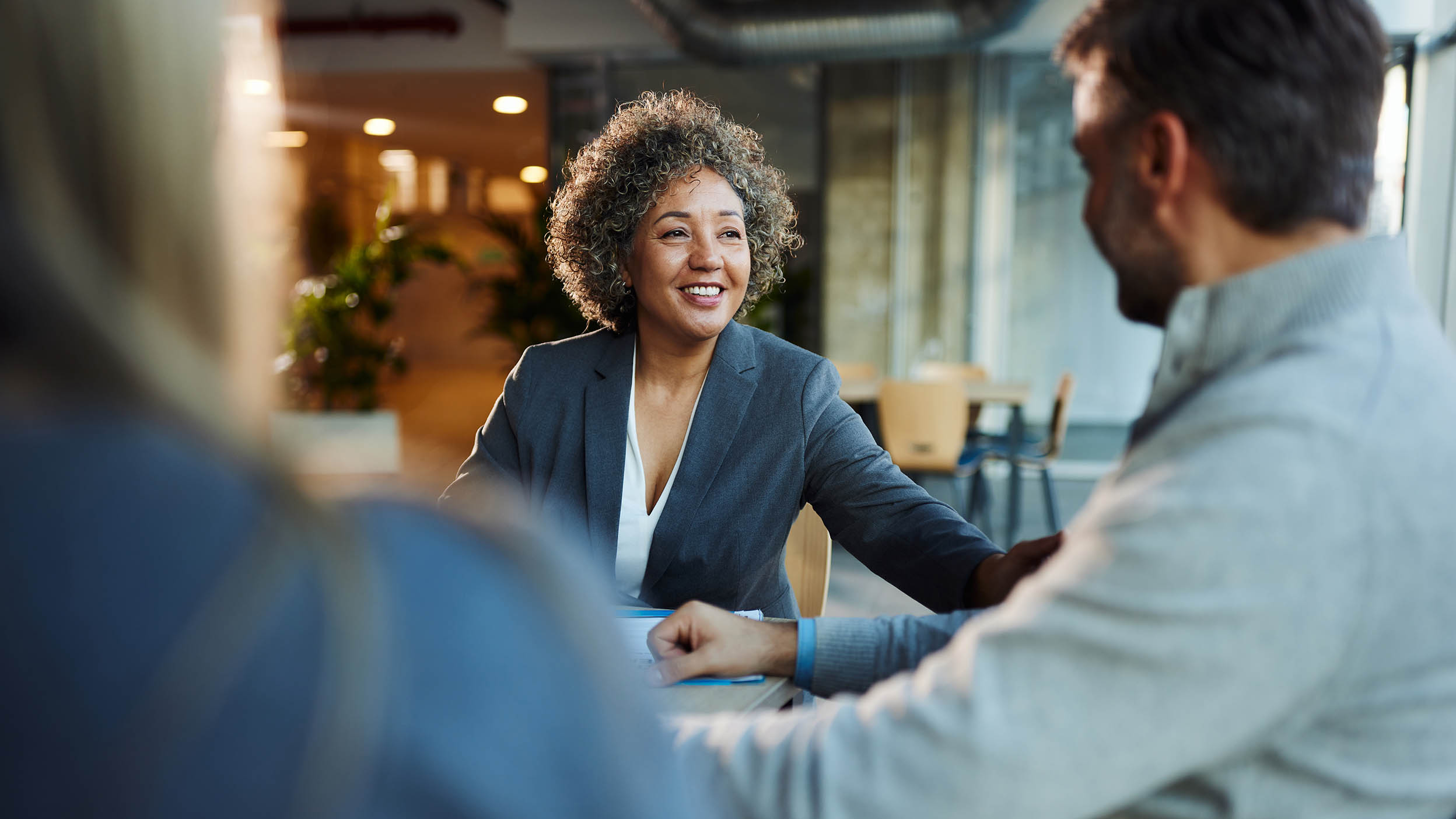 Happy advisor talking to her customers in the office