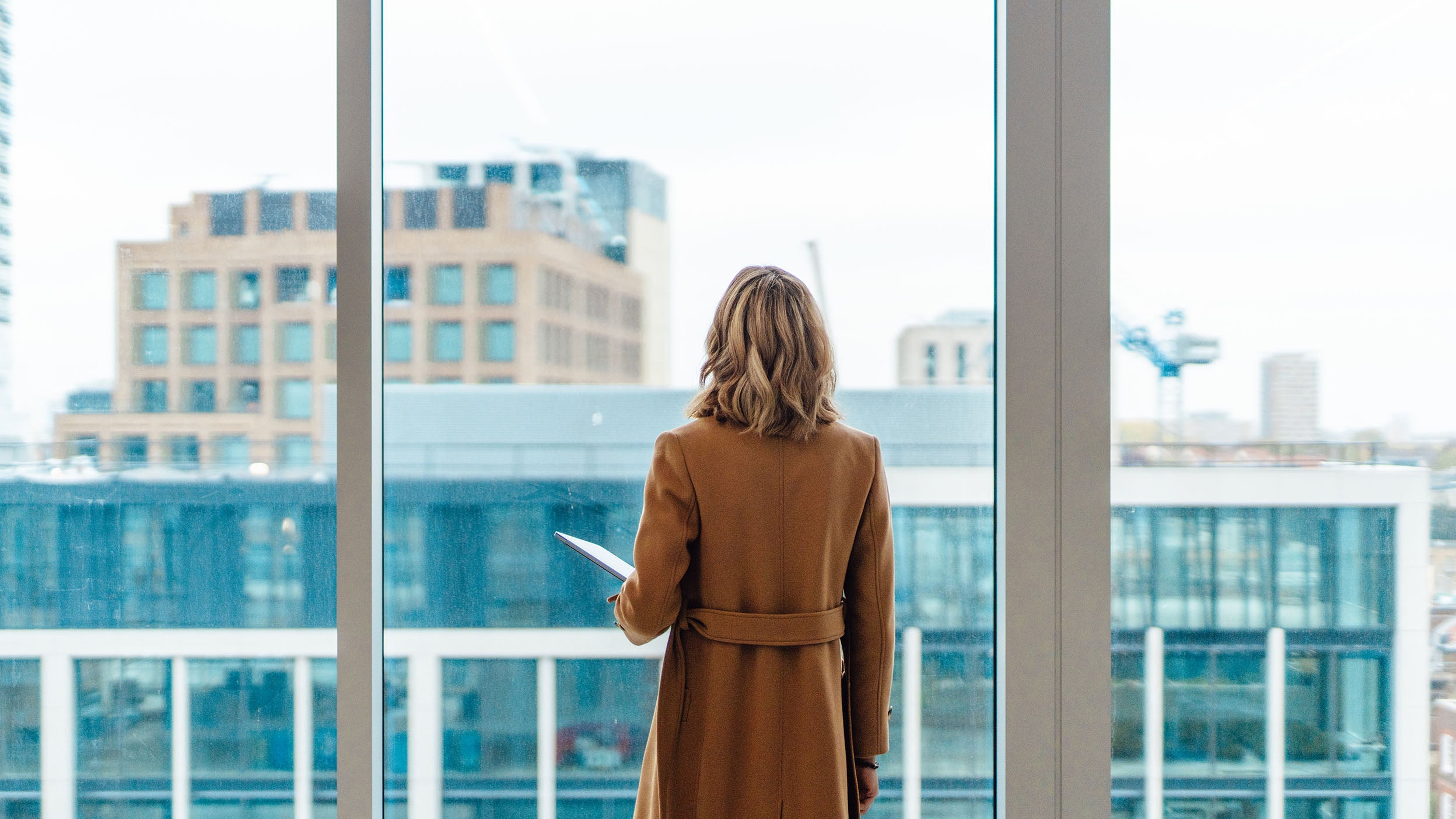 A woman looking through a office building window